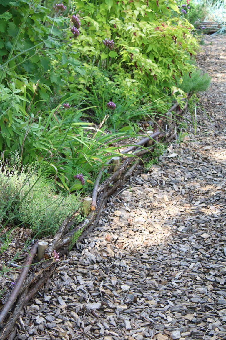 chemin en copeaux de bois  et bordure en branchage